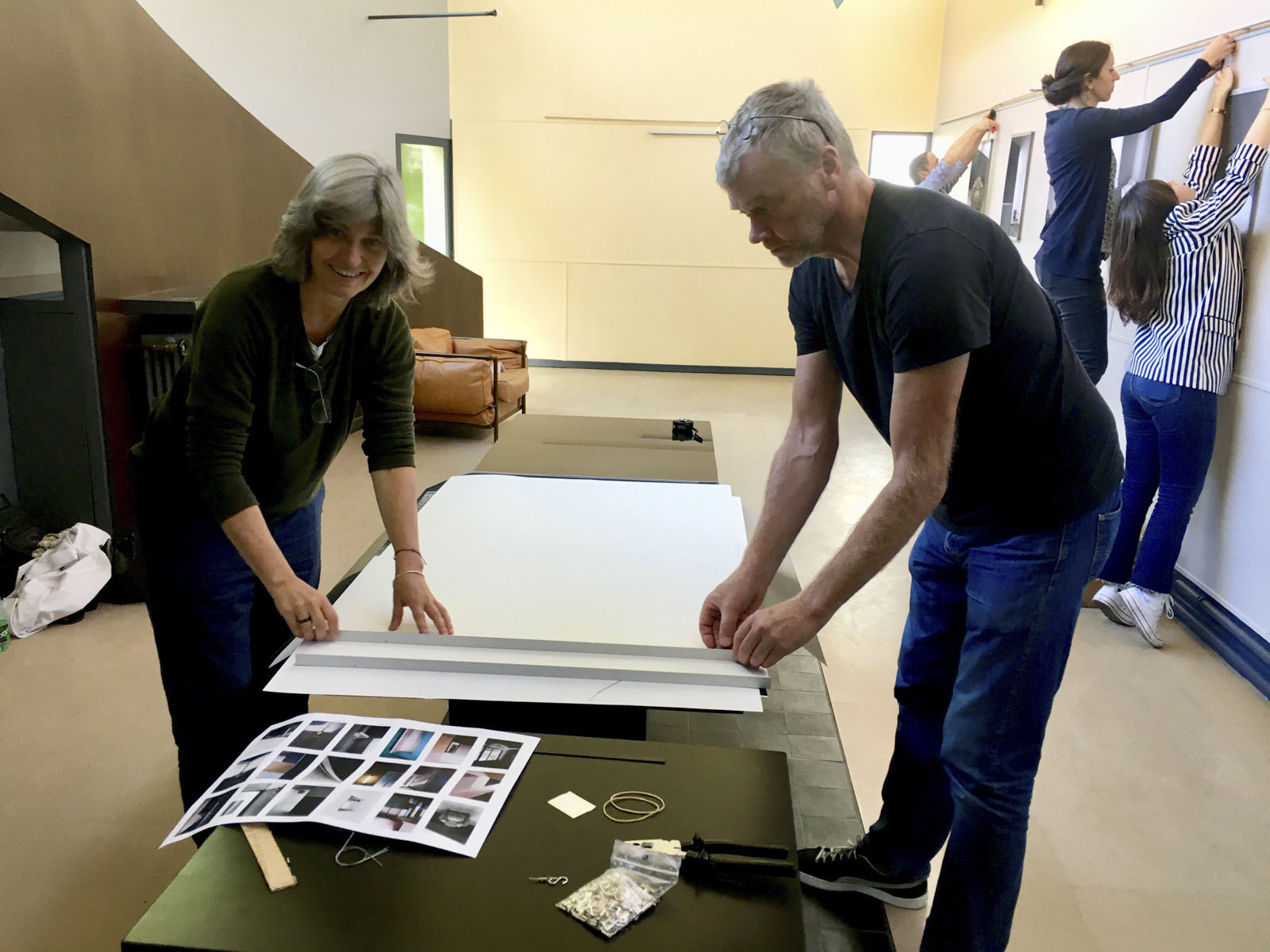 Deux personnes préparent l’accrochage d’une exposition