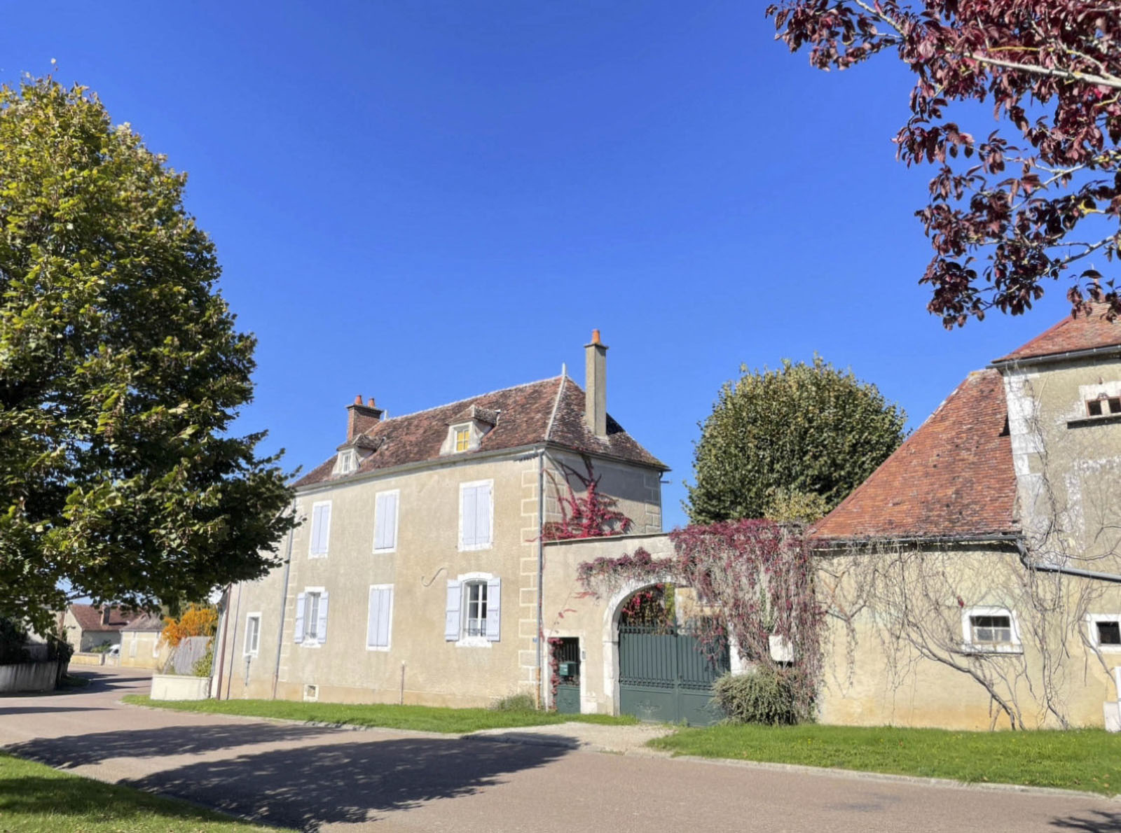 La maison de Maison Farouche à Lignières, façade en pierre et volets bleus sous un ciel clair