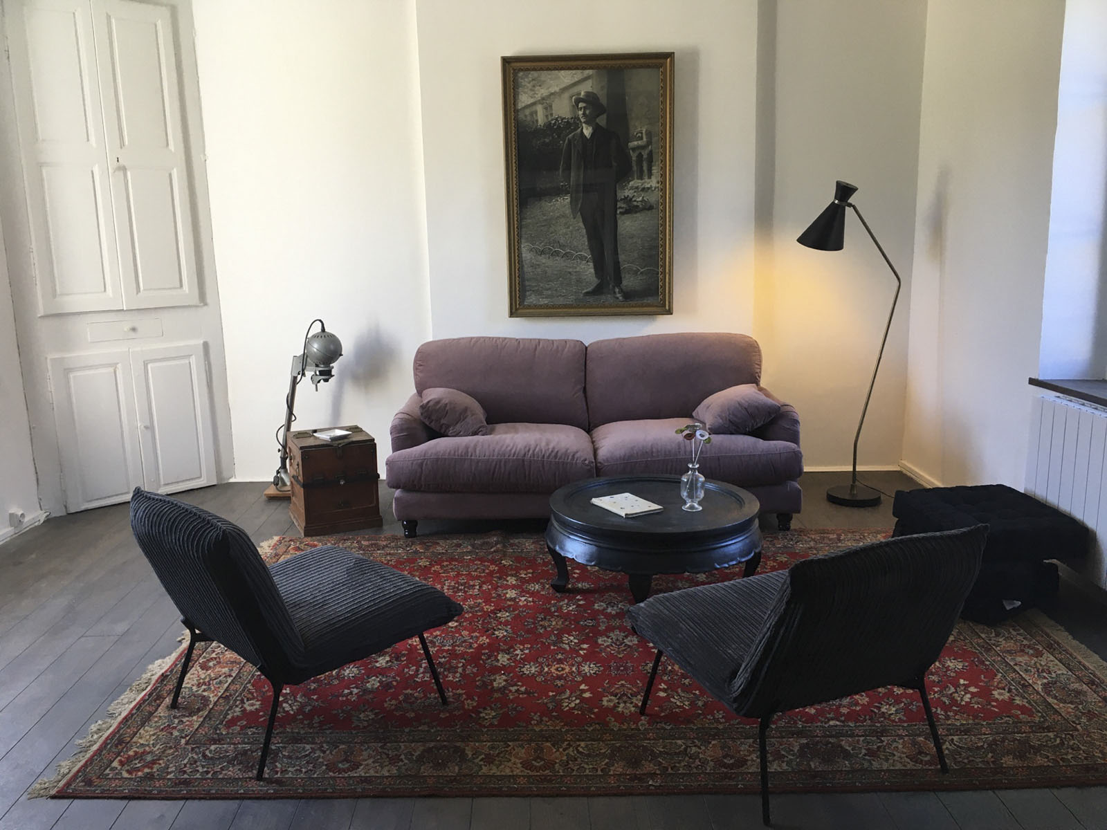 Salon du duplex : canapé, fauteuils et grand portrait en noir et blanc au mur
